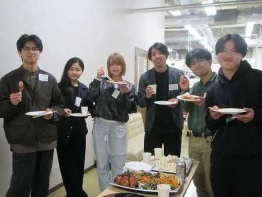 懇親会で料理を手にする研究室メンバー