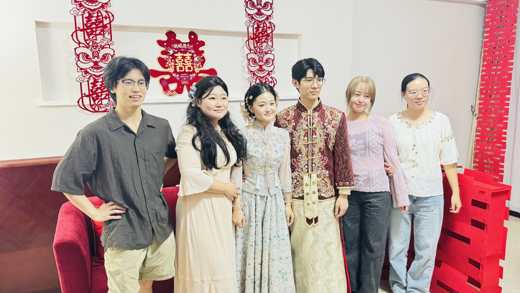 中国式の婚礼衣装の新郎新婦とお祝いに駆けつけたメンバー