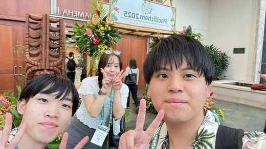 Pacifichem 2025の看板の前で自撮りするメンバー