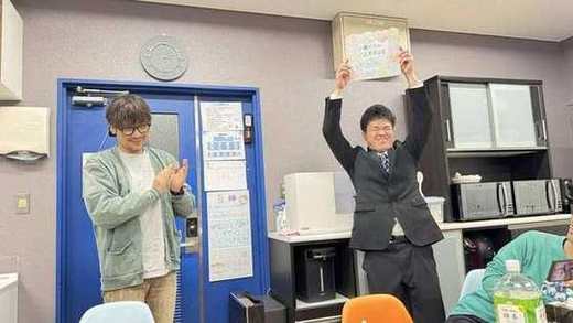 記念品を掲げる修了生