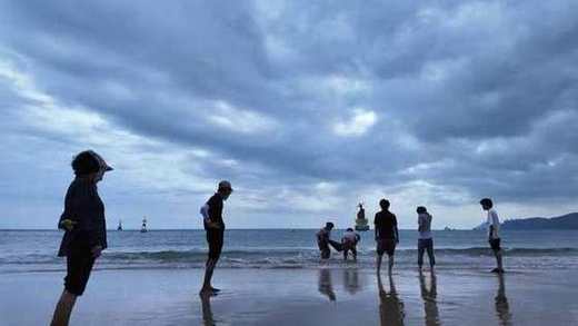 曇り空の海辺で遊ぶメンバー